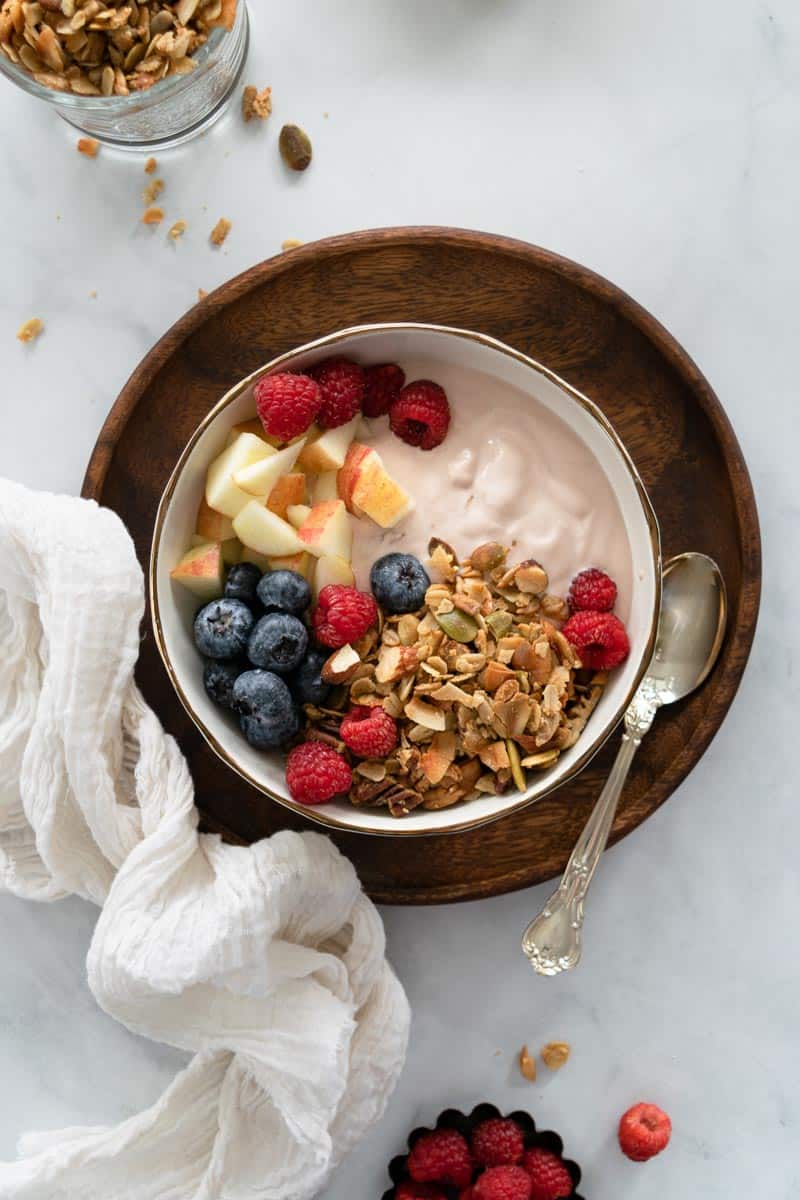 Coconut Almond Granola in a bowl served with yogurt and fresh fruit. 