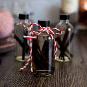 Three small bottles of vanilla extract with a red and white ribbon.