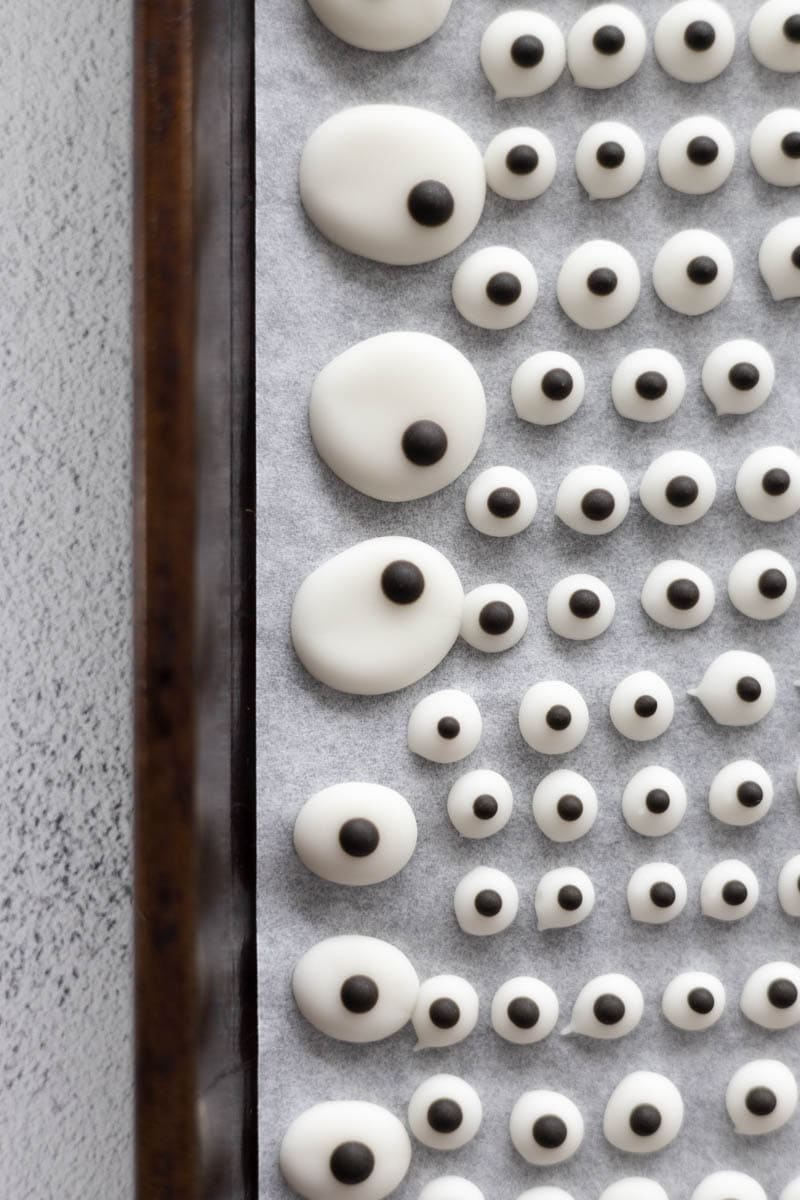 Irregularly shaped edible candy eyeballs on a baking sheet.