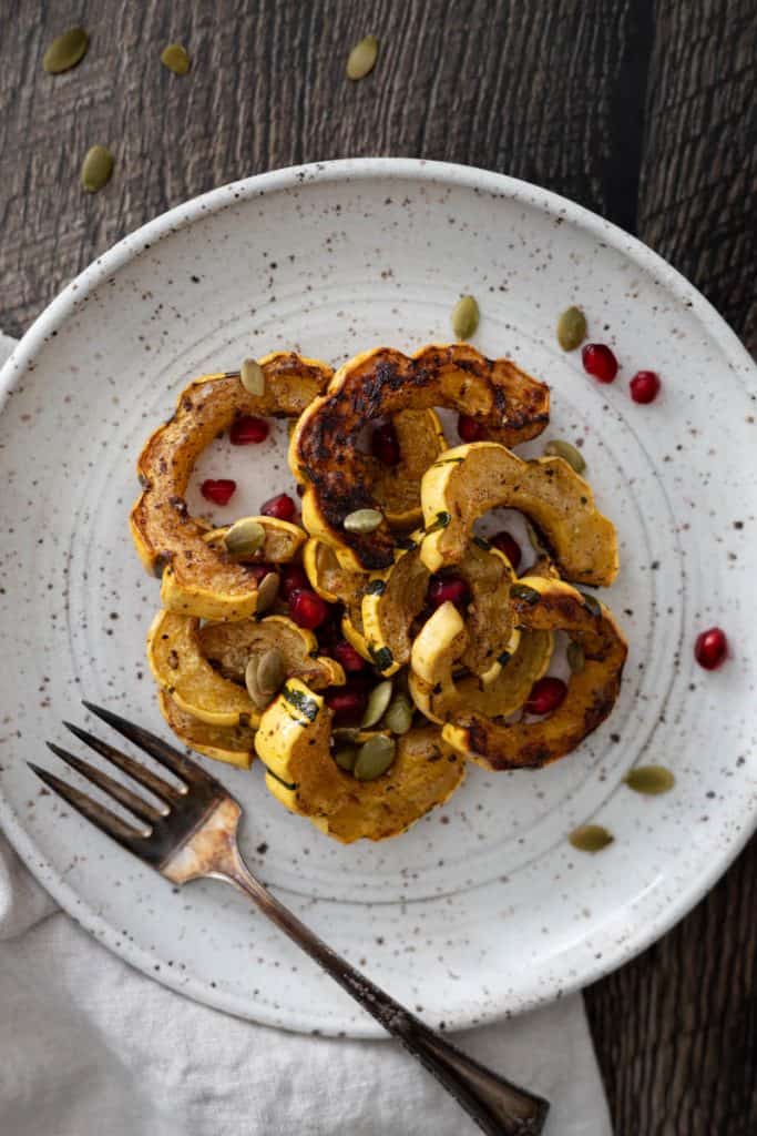 Roasted Delicata Squash with Balsamic and Pomegranate Seeds on a plate