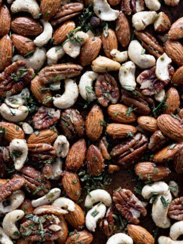 Spiced nuts with rosemary on a baking sheet.