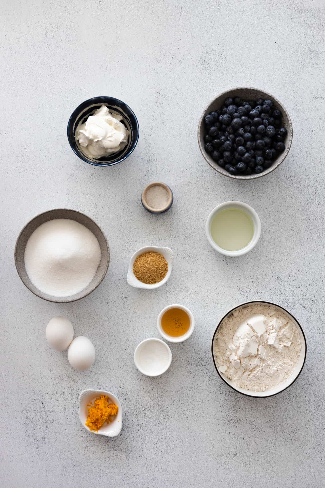 Ingredients for blueberry sour cream muffins in small bowls. 