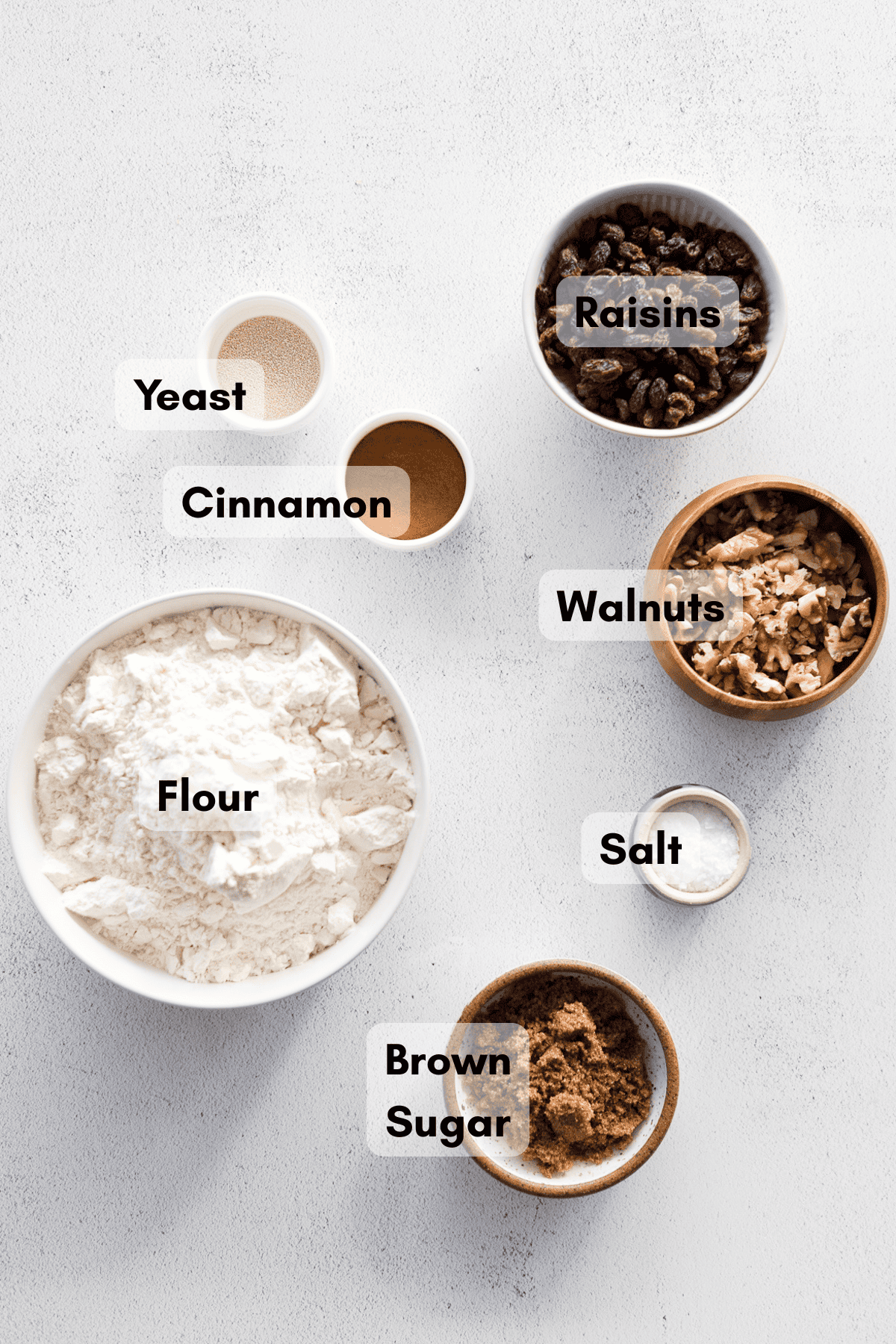 Ingredients for No-Knead Walnut Raisin Bread in small bowls.