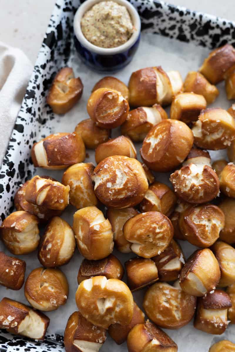 Sourdough pretzel bites on a black and white speckled tray.