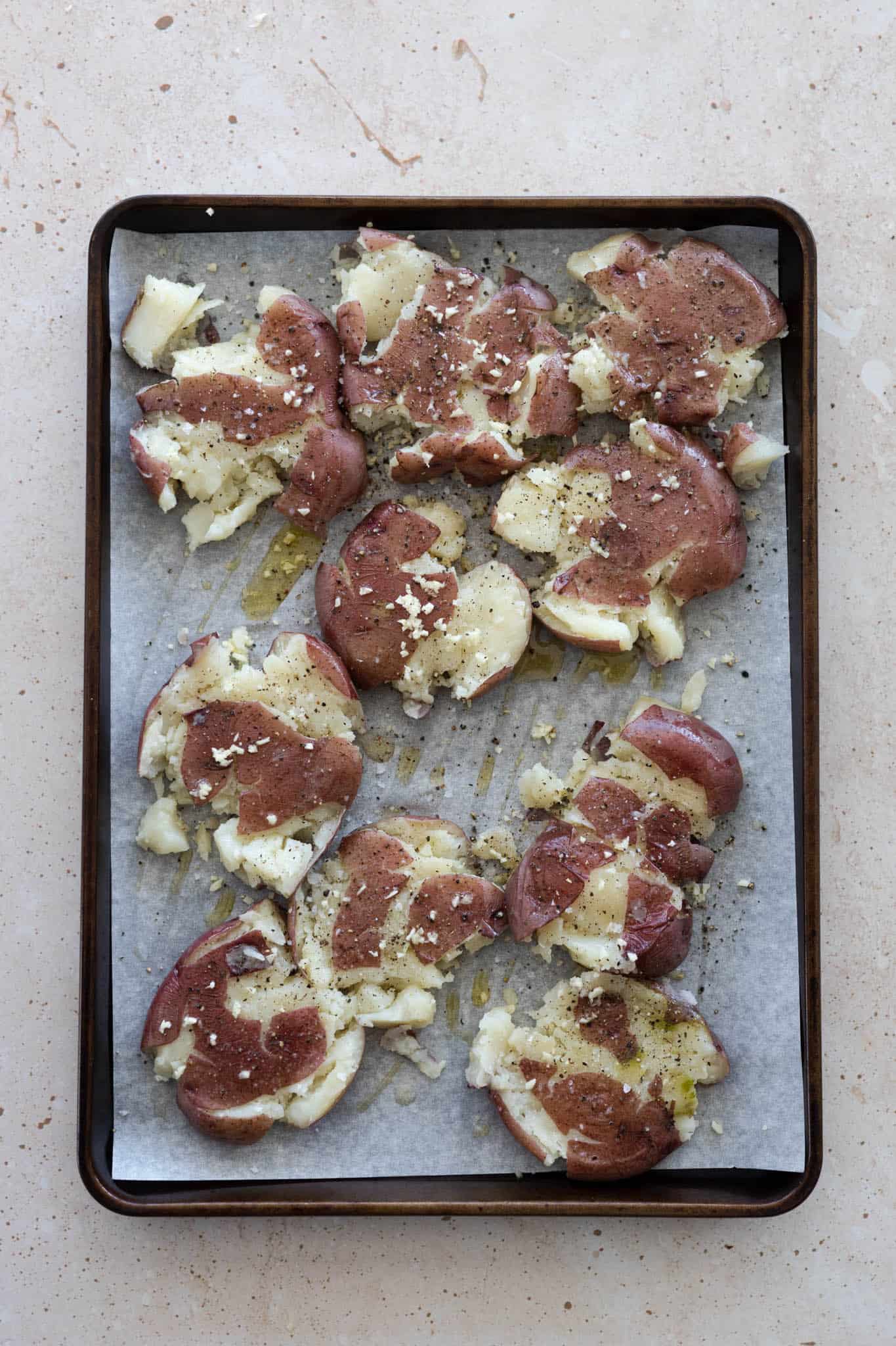 A tray of smashed potatoes ready for baking. 