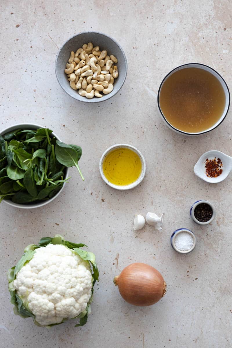 Ingredients for Spinach Cauliflower Soup in small bowls on a table. 