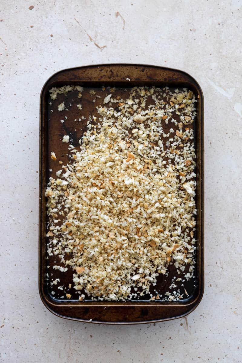 Breadcrumbs tossed with olive oil, salt and pepper on a baking sheet.