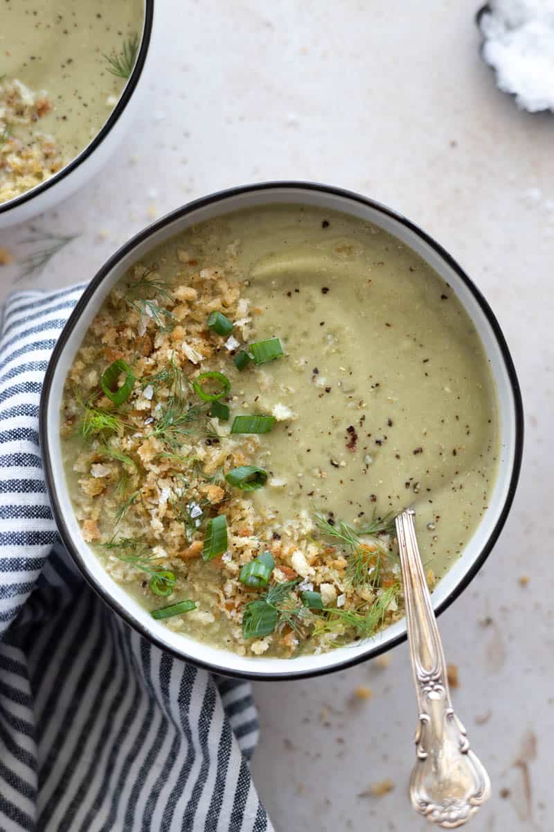 Spinach Cauliflower Soup in a bowl with a spoon and a blue and white striped linen. 