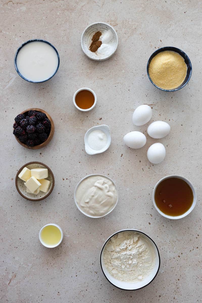 Ingredients for Cornmeal Waffles with Blackberry Bourbon Maple Syrup in small bowls on a table. 