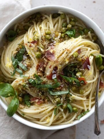 Pasta with Peas and Prosciutto in a white bowl.