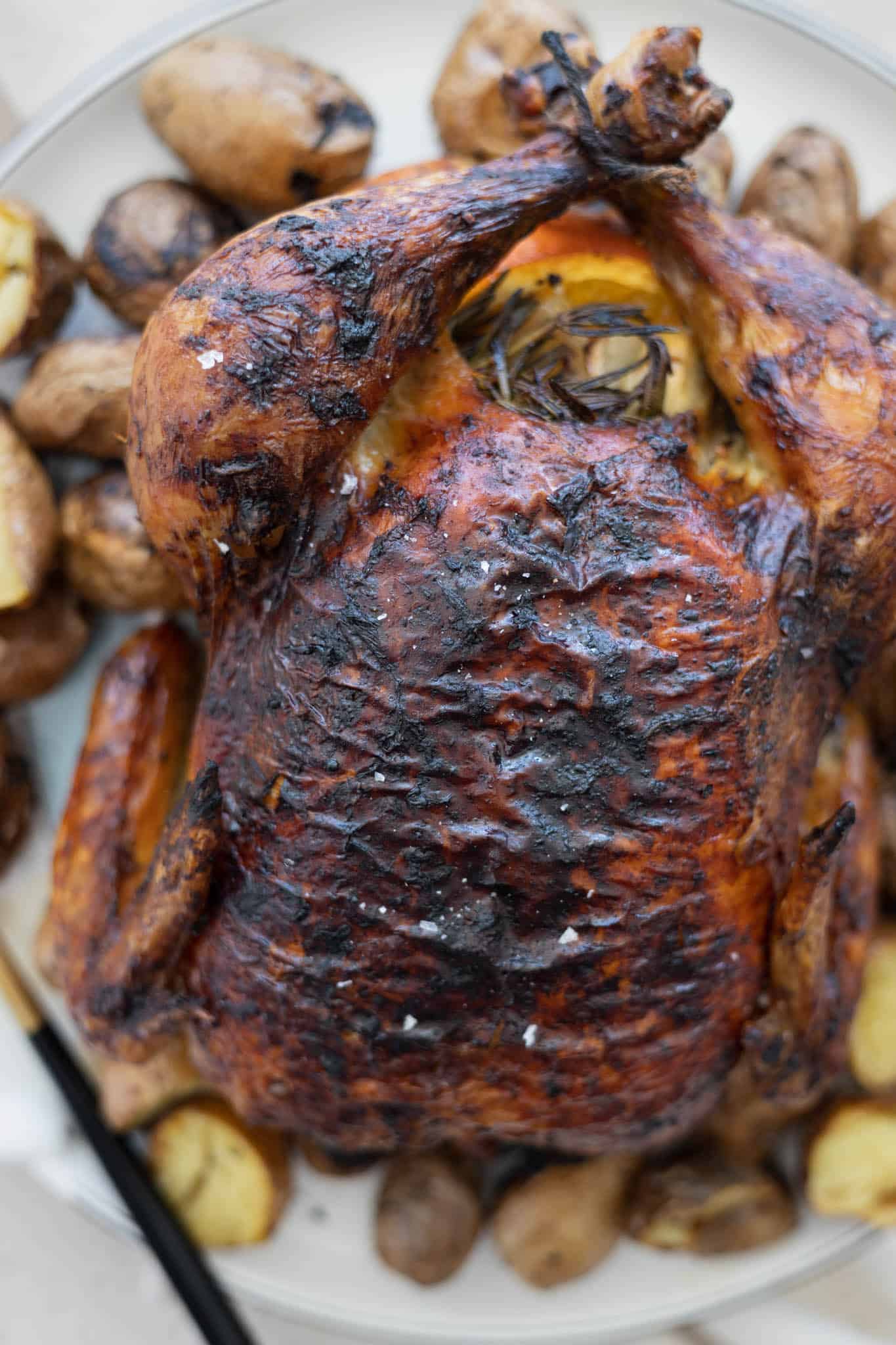 A closeup of the crispy skin of the bird on the serving platter.