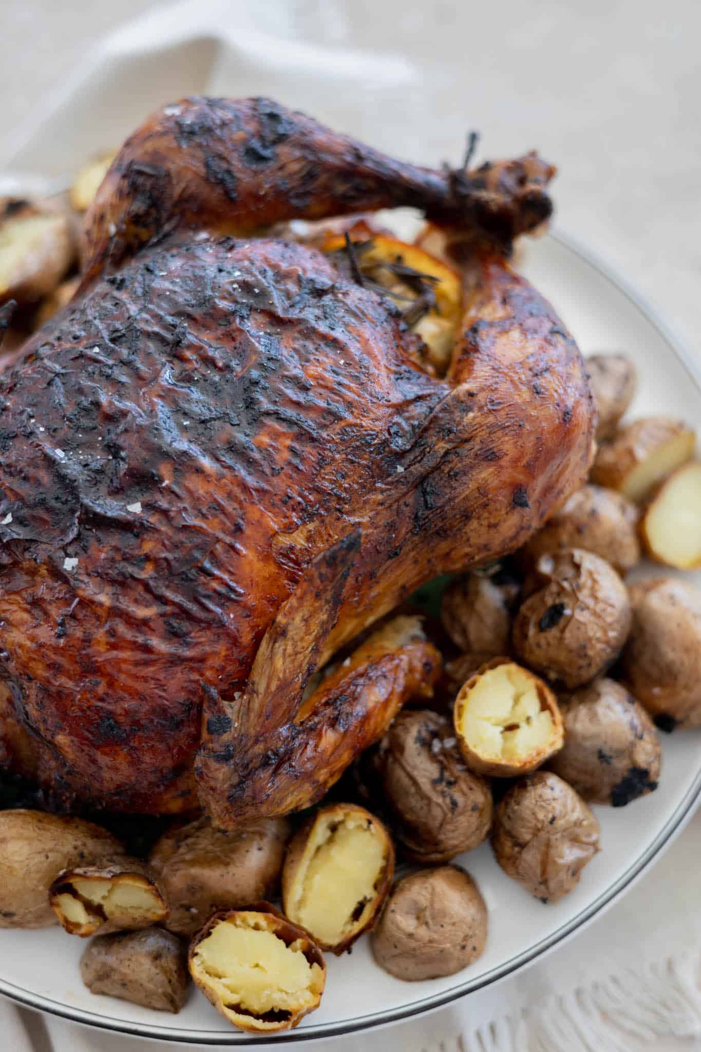 A closeup of the crispy skin on the bird on a serving platter.