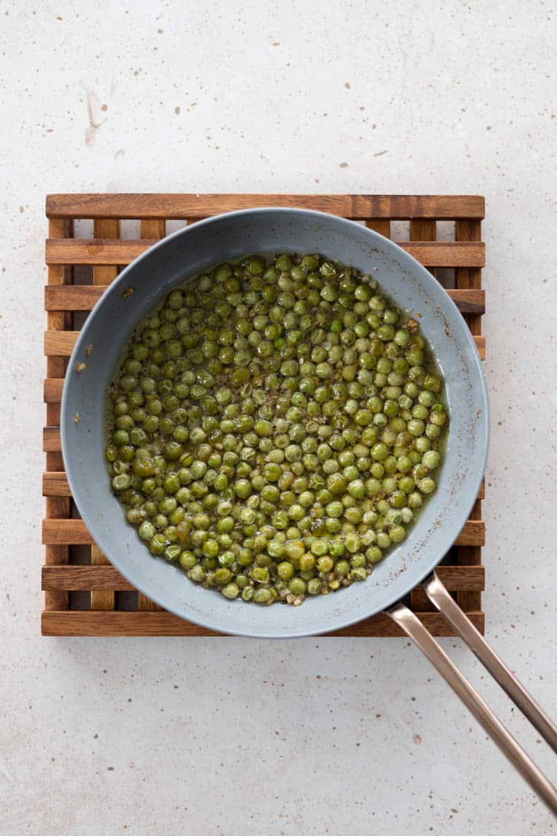 Cooked peas and olive oil in a small skillet.