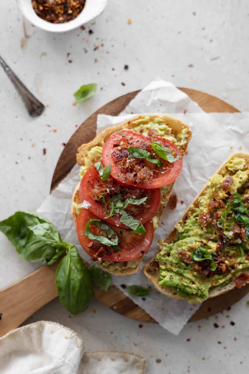 Avocado Toast with Tomato on a small wooden board.
