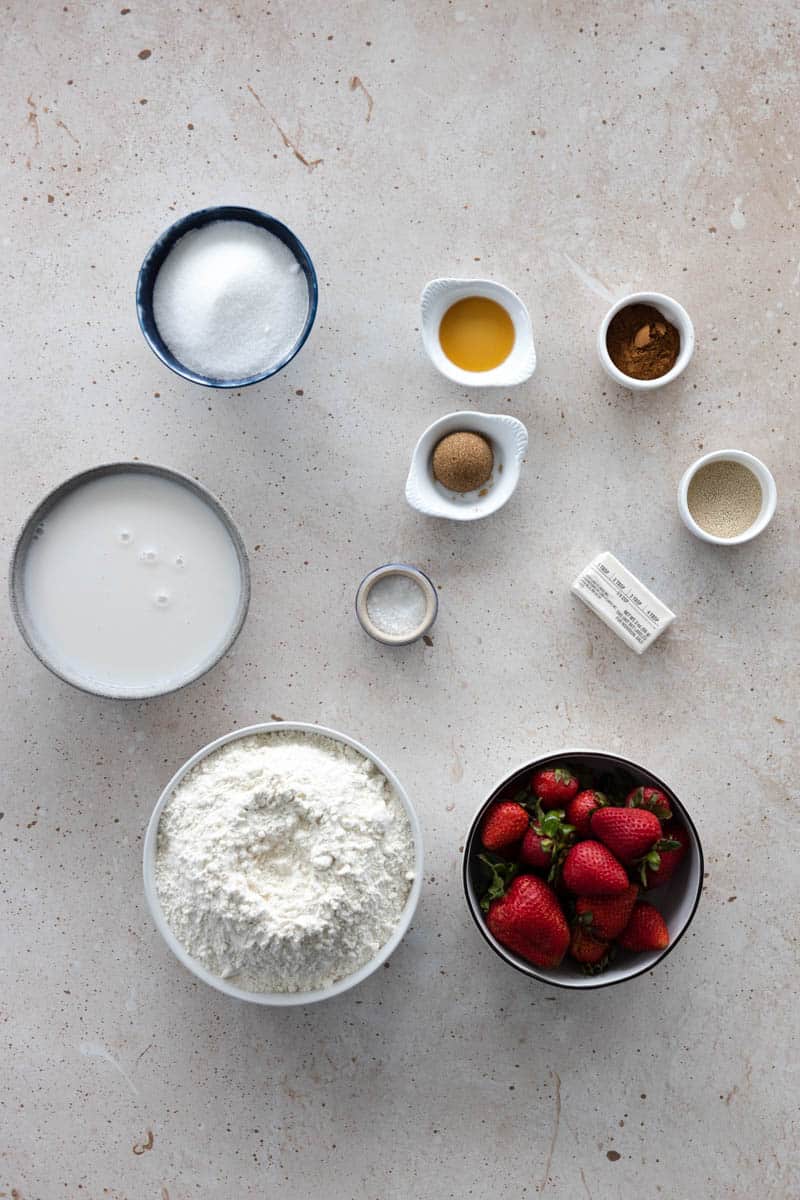 Ingredients for cinnamon sugar pretzels in small bowls on a table. 