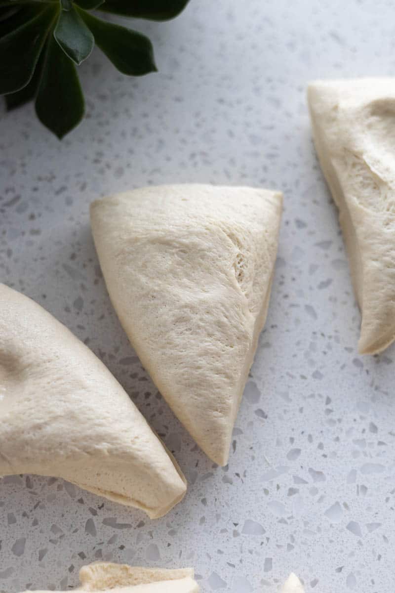 A triangular section of dough before it's rolled into a pretzel.