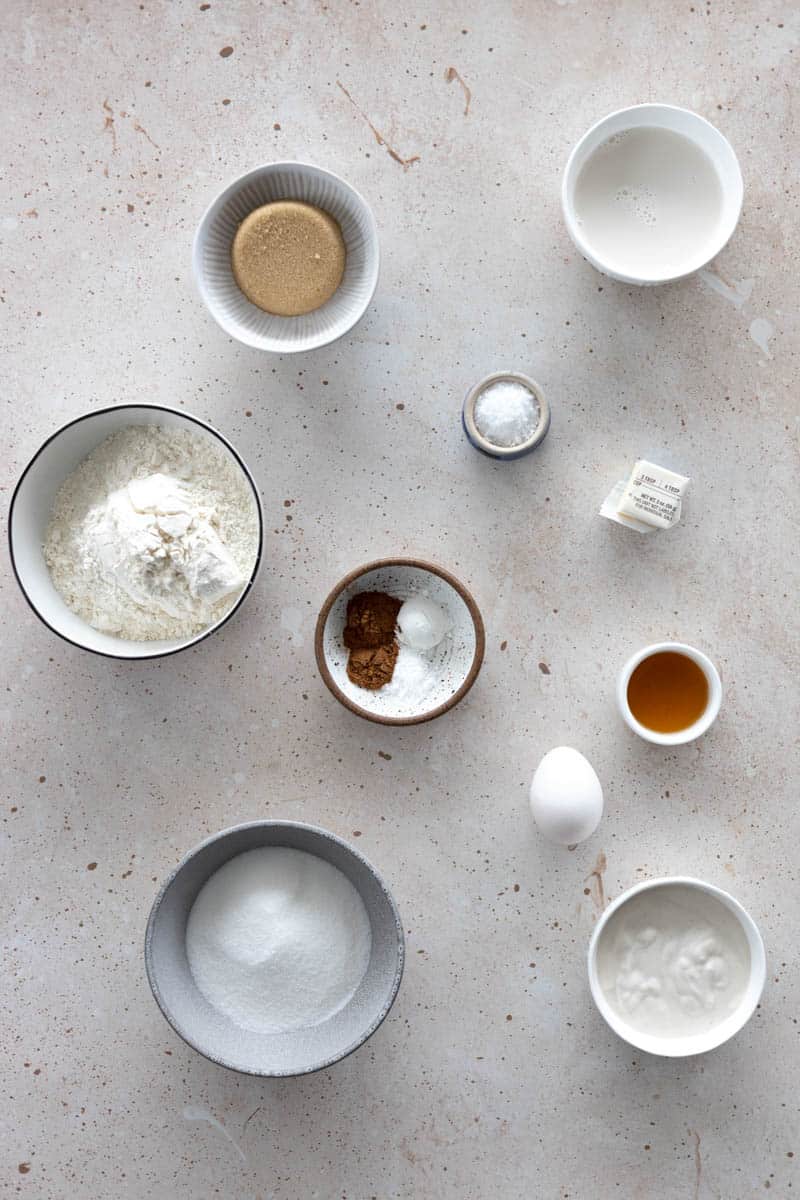 Ingredients for Baked Cinnamon Sugar Donuts in small bowls on a table.