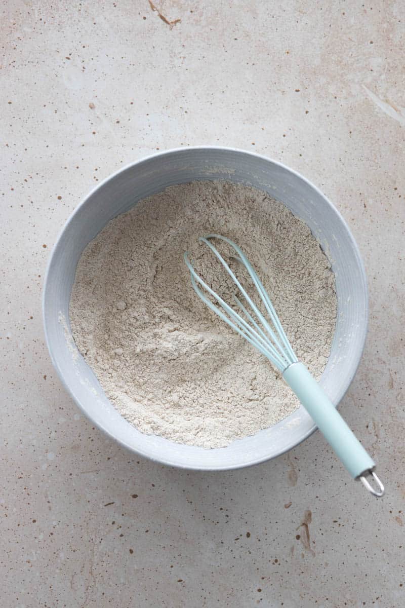 Dry ingredients mixed together in a bowl with a whisk.