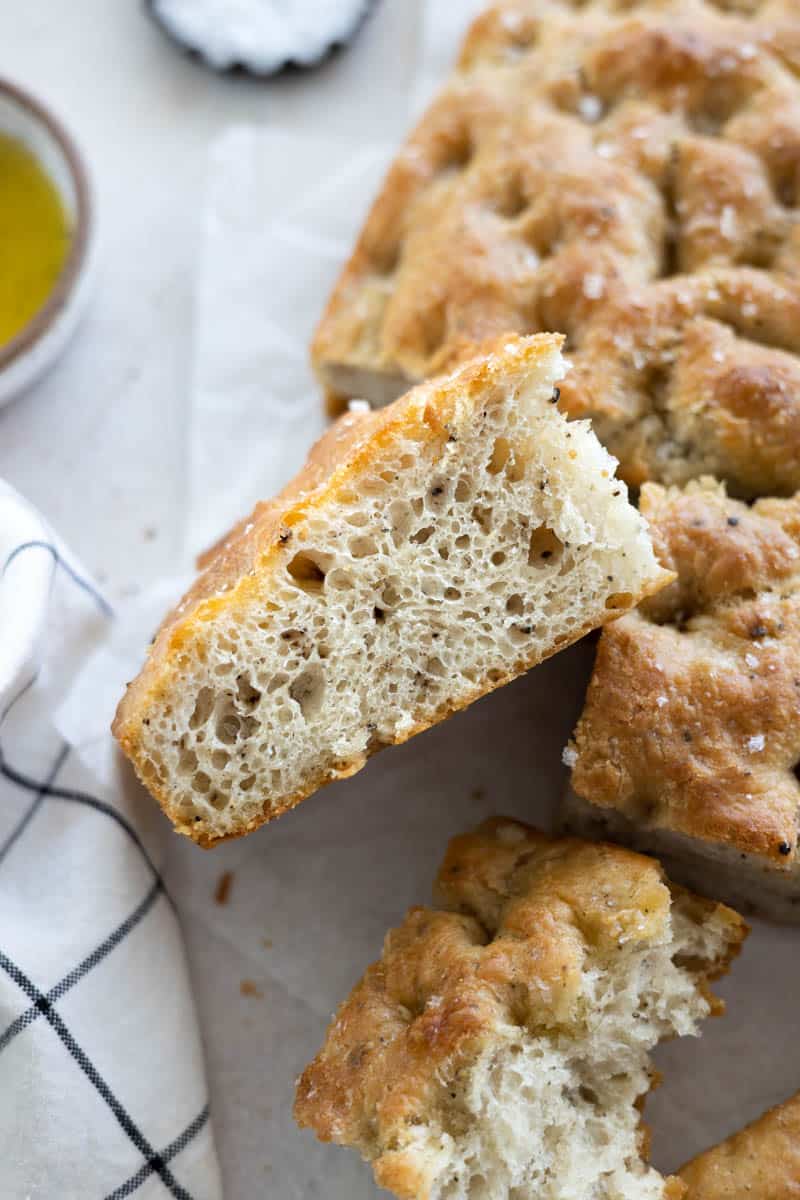 A side view of a slice of Black Pepper Focaccia with bubbly air pockets.
