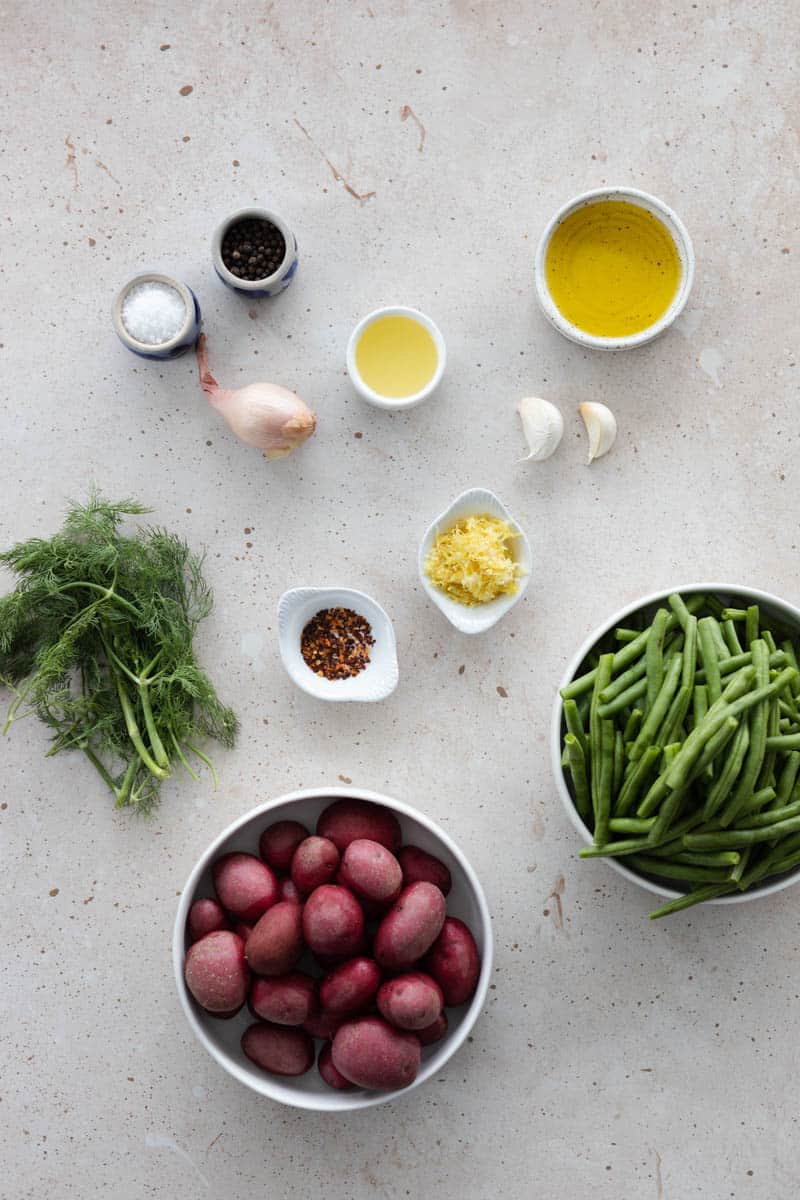 Ingredients for Green Beans and Potatoes in small bowls on a table. 