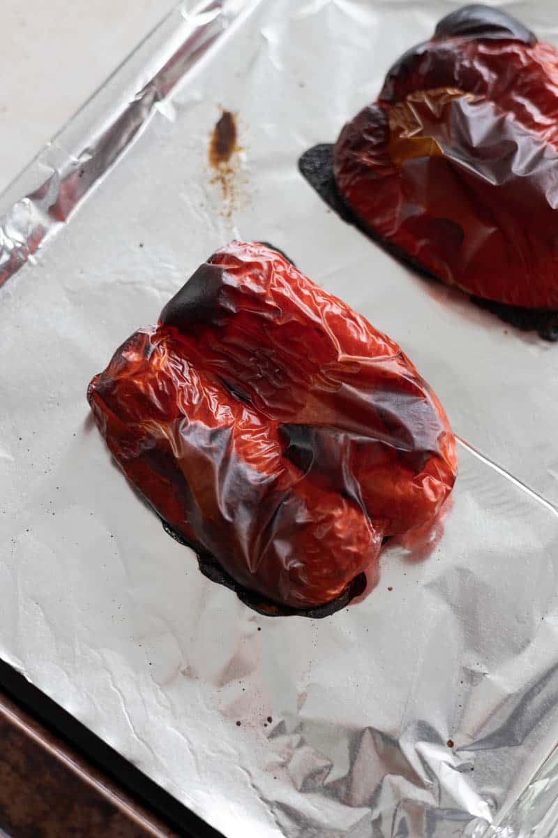 Roasted red peppers on a baking sheet.