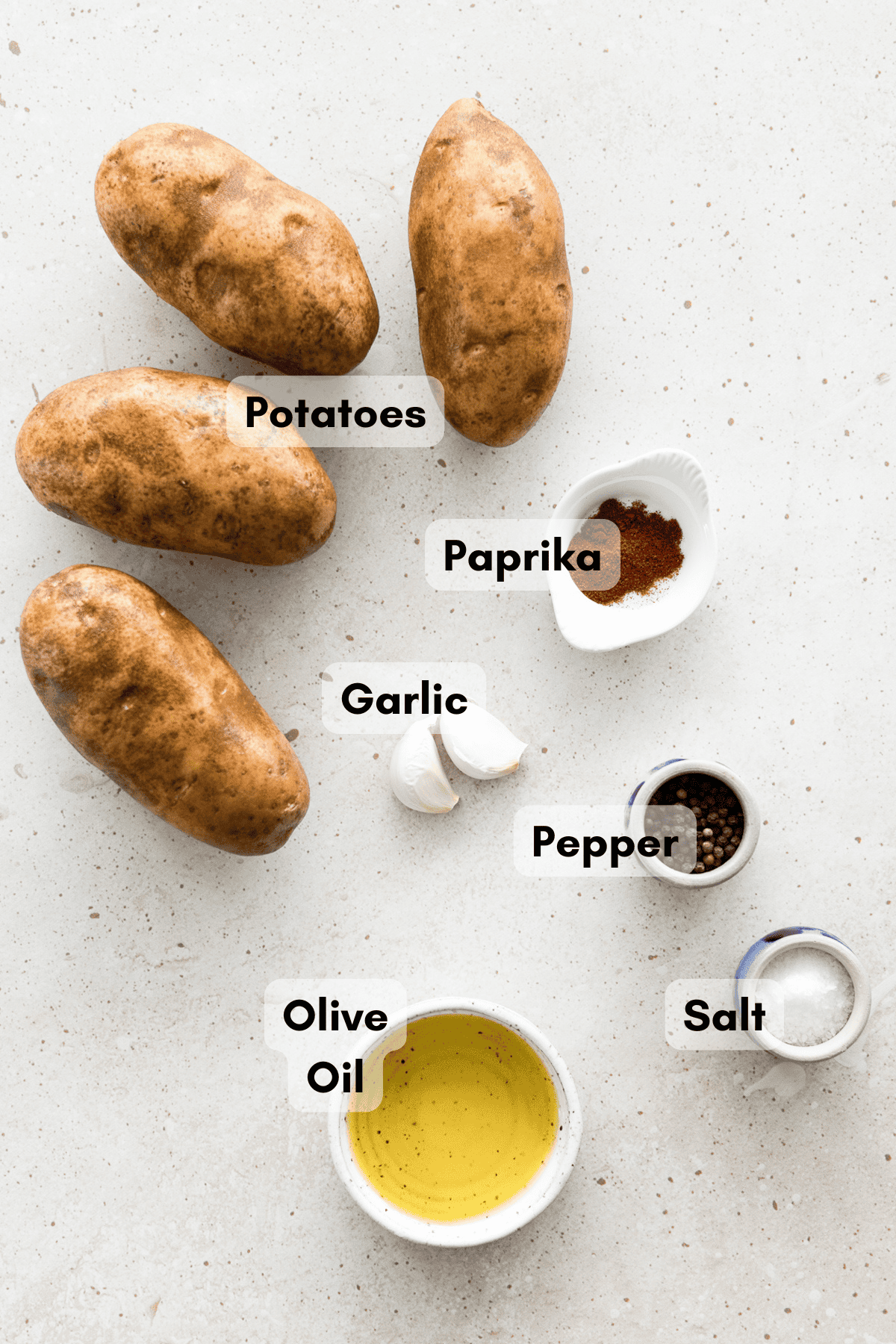 Ingredients for crispy garlic potato wedges in small bowls.