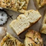 A closeup side view of a slice of focaccia with air bubbles in the dough.