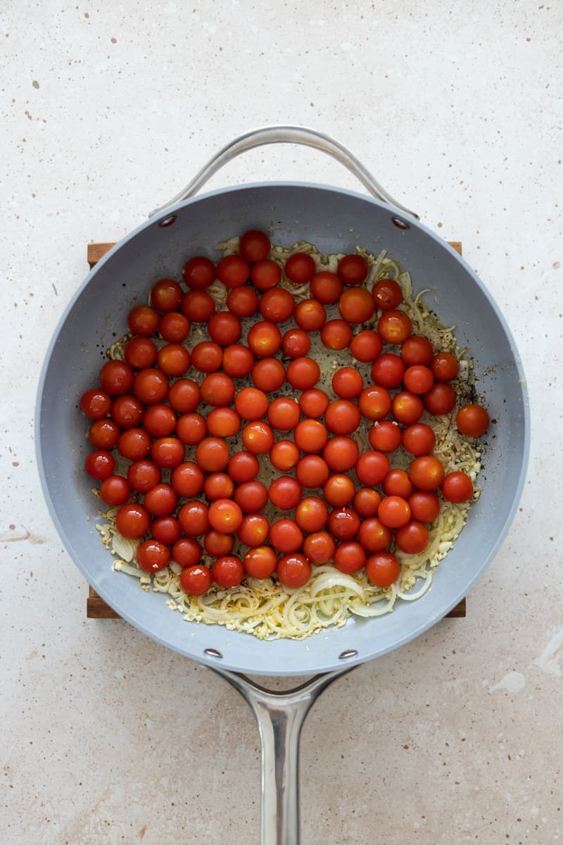 Cherry tomatoes added to the skillet to sautée. 