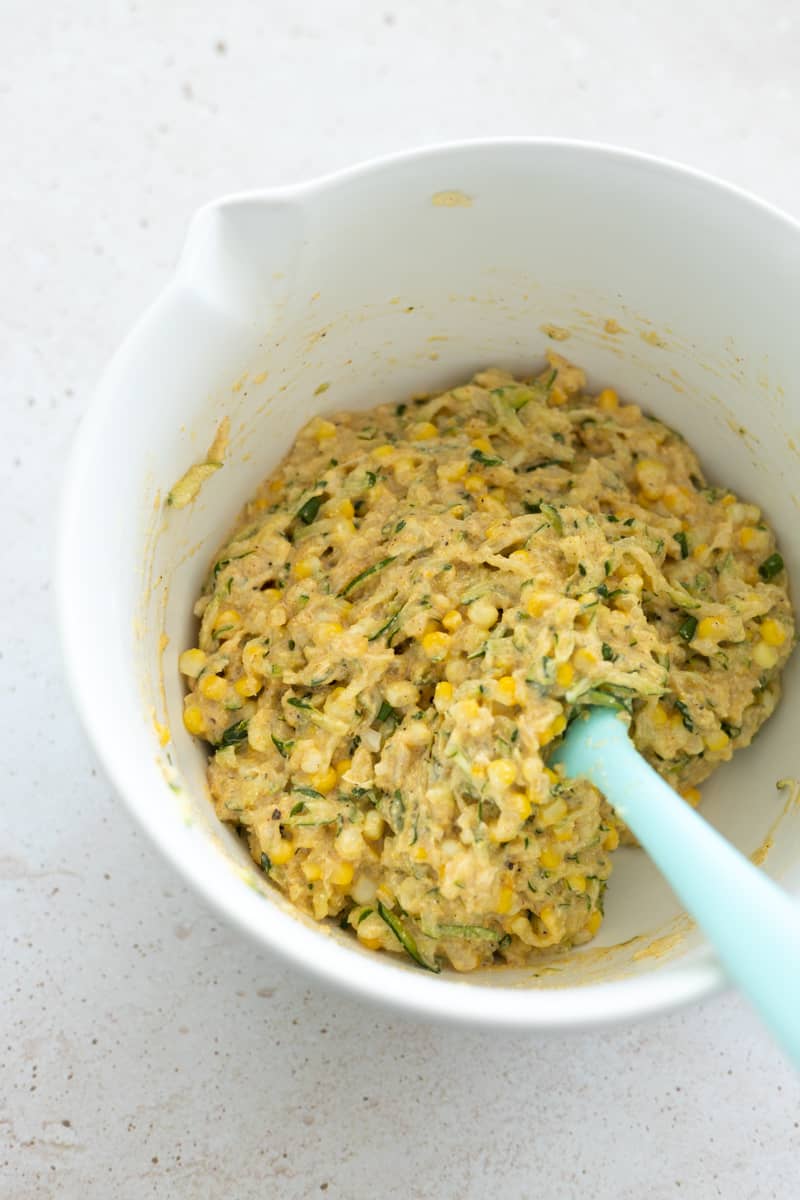 Fritters batter stirred together in a white bowl. 