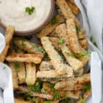 A closeup of baked zucchini sticks in a basket.