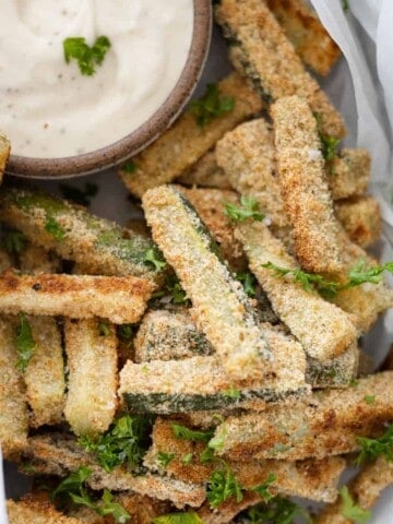 A closeup of baked zucchini sticks in a basket.