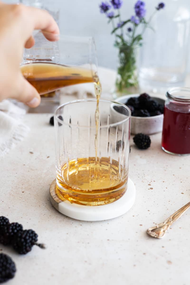 Bourbon being poured into an Old Fashioned glass. 