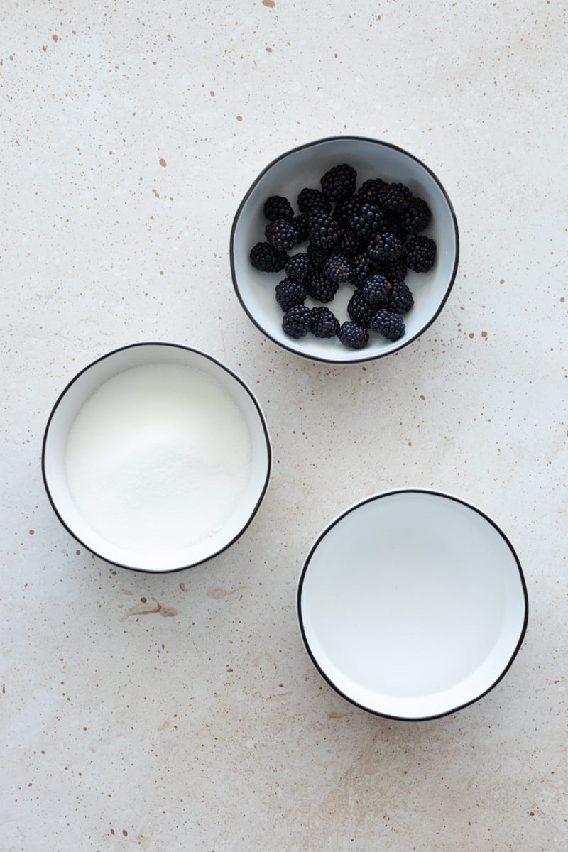 Ingredients for blackberry simple syrup in white bowls. 