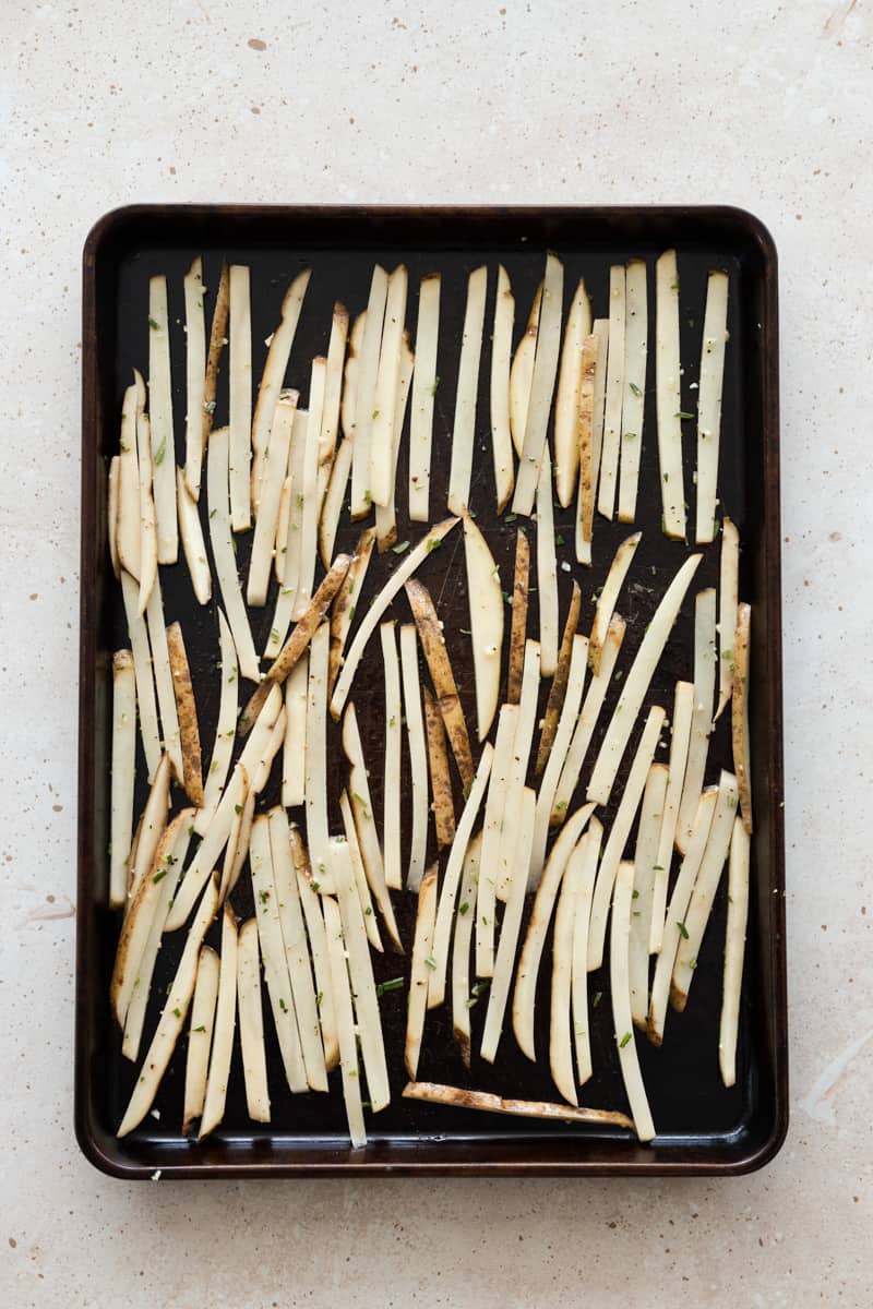 Fries evenly spread in one layer on a baking sheet.