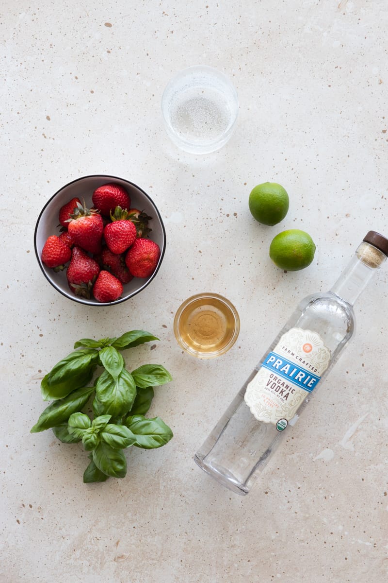 Ingredients for a strawberry basil vodka cocktail. 