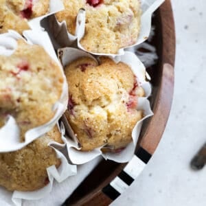 A pile of Strawberry Rhubarb Muffins on a tray.