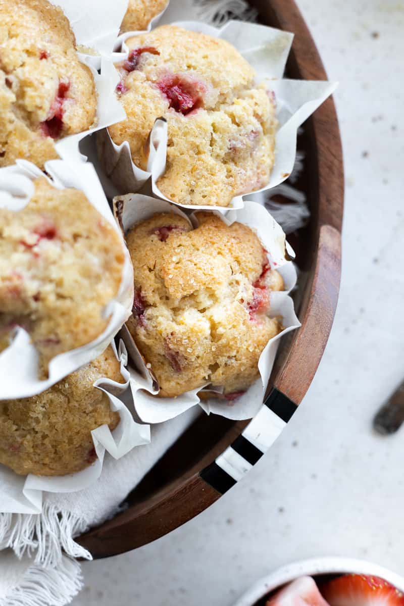 A closeup of Strawberry Rhubarb Muffins on a wooden tray.