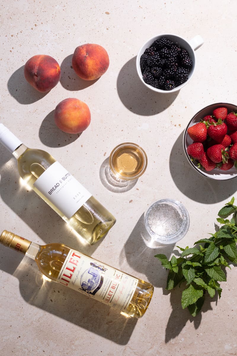 Ingredients for simple white sangria laying on a tabletop.