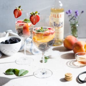 Simple white sangria in wine glasses with fresh fruit.