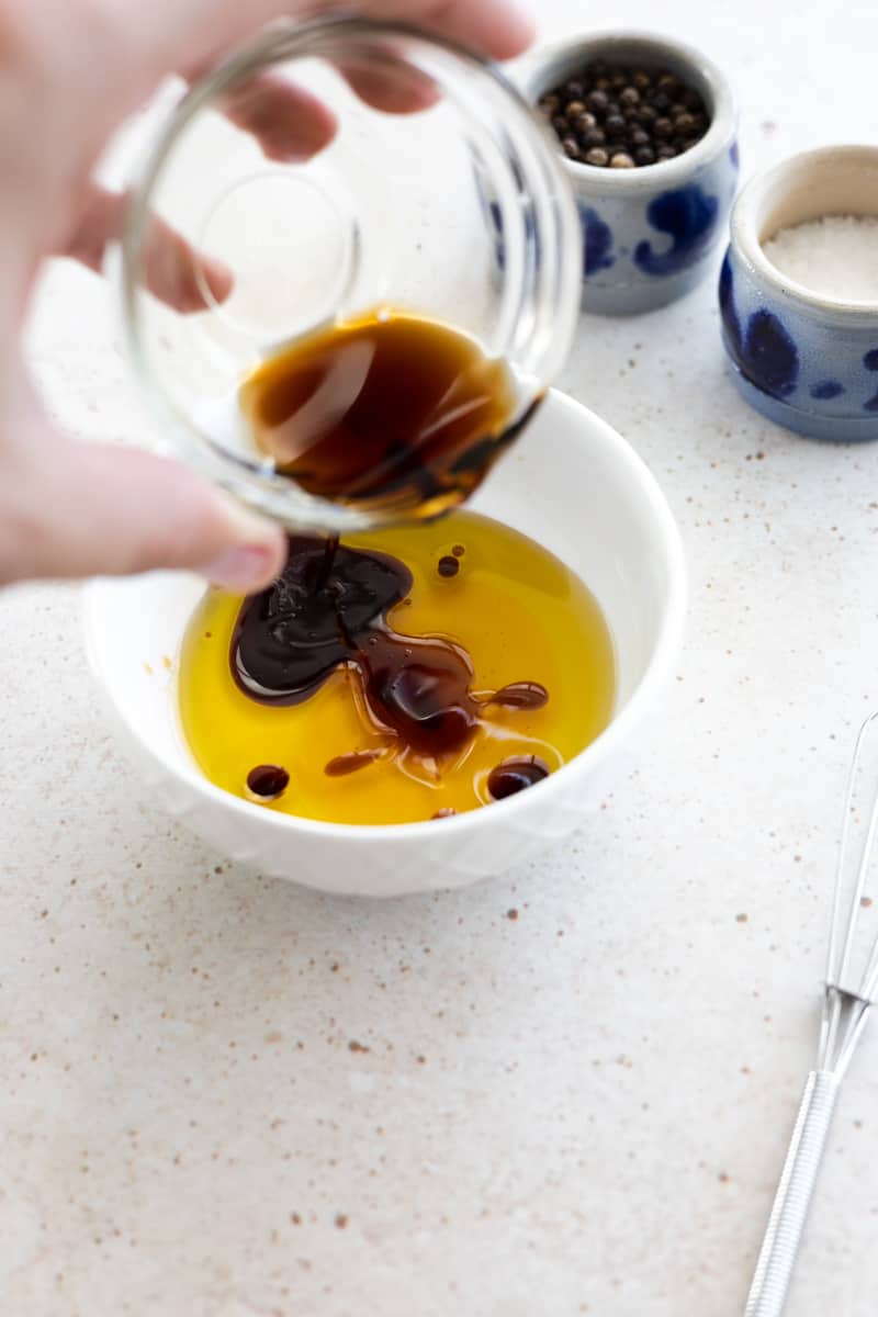 Dressing ingredients being mixed in a small white bowl. 