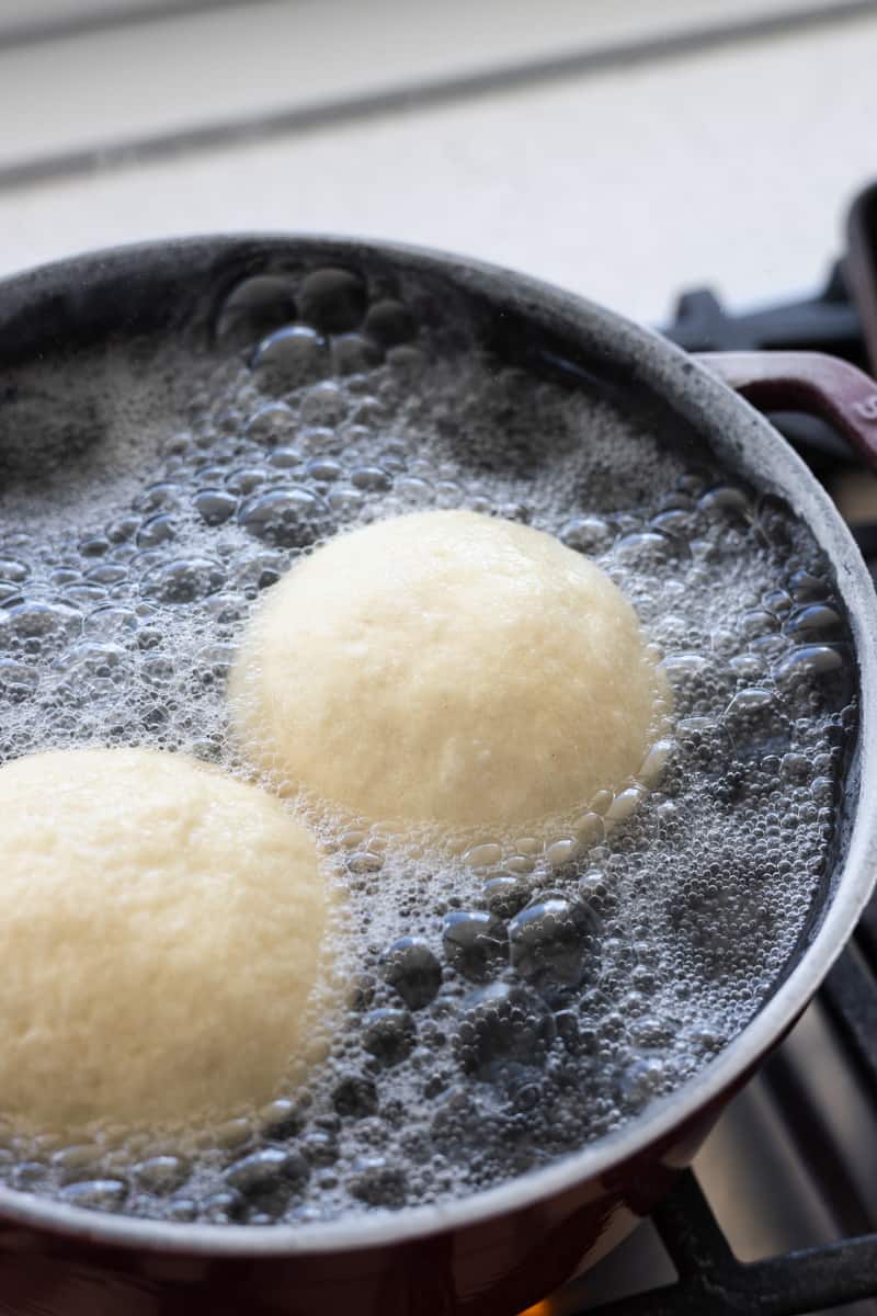 Buns boiling in a large pot. 