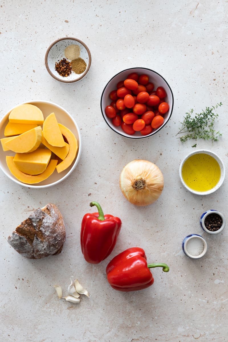 Ingredients for butternut squash and red pepper soup in small bowls. 