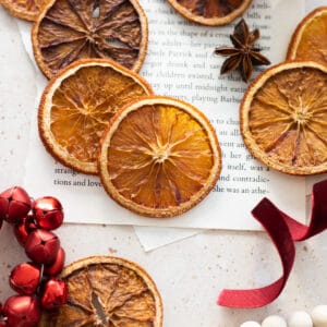 Dried Sliced Oranges with red ribbon, red jingle bells, and other holiday accessories.
