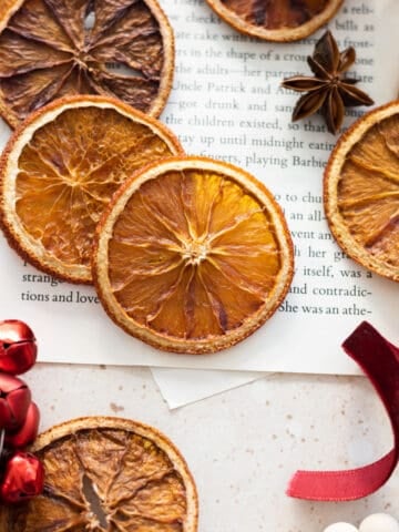 Dried Sliced Oranges with red ribbon, red jingle bells, and other holiday accessories.