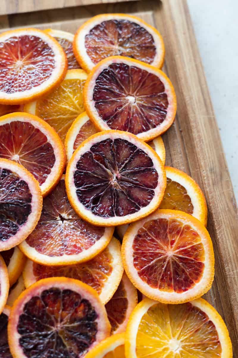 Sliced oranges on a wooden cutting board. 