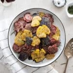 Smashed fingerling potatoes on a white platter.