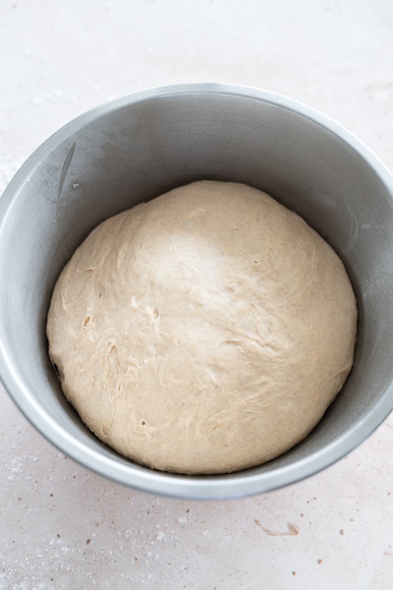 Dough in a large metal bowl after the first rise. 