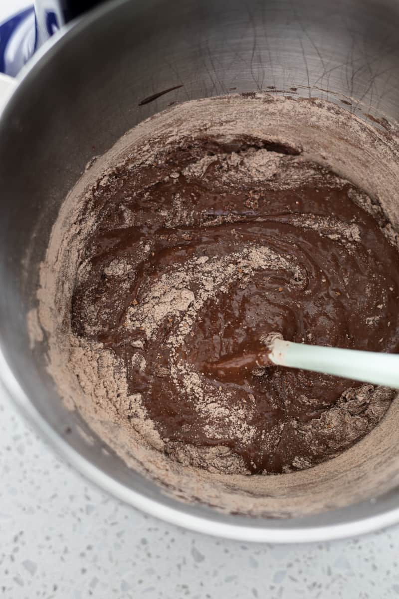 Dry ingredients being stirred into the chcoolate mixture. 