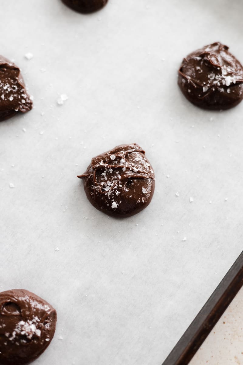 Dough balls on a baking sheet sprinkled with sea salt. 