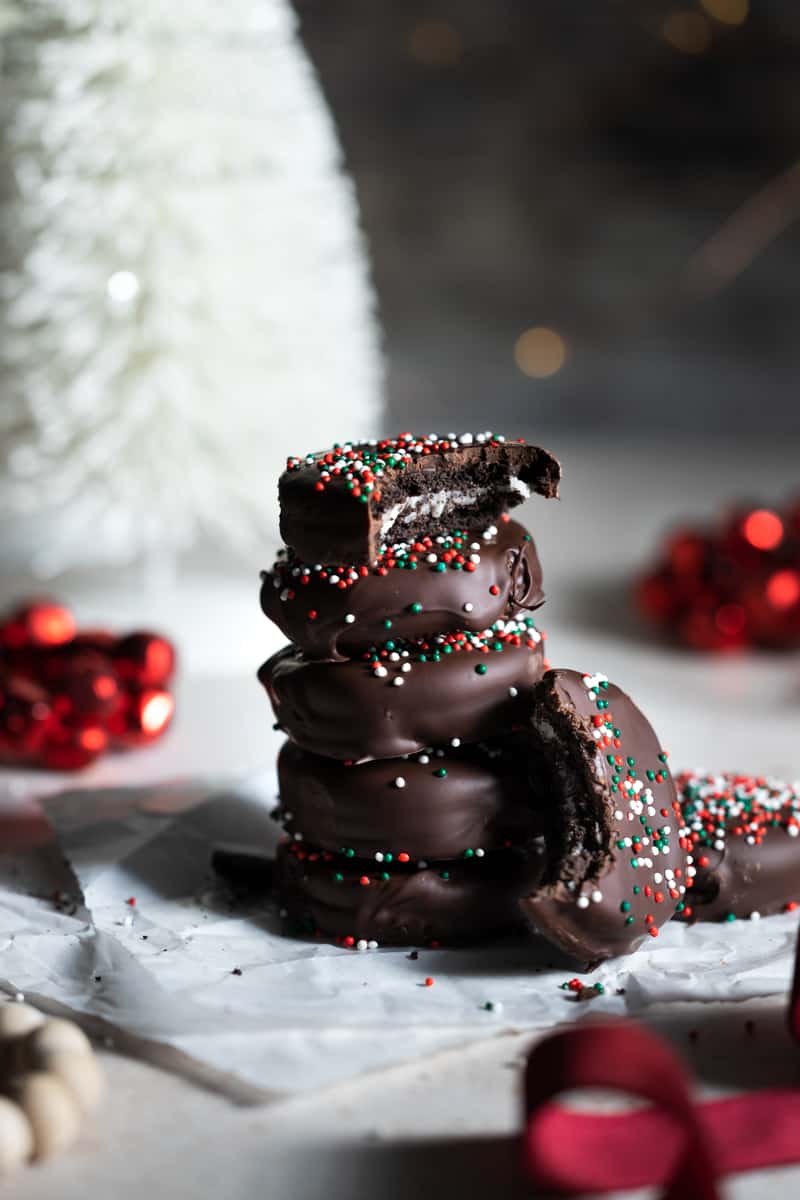 A stack of Chocolate Covered OREOs with one missing a bite. 